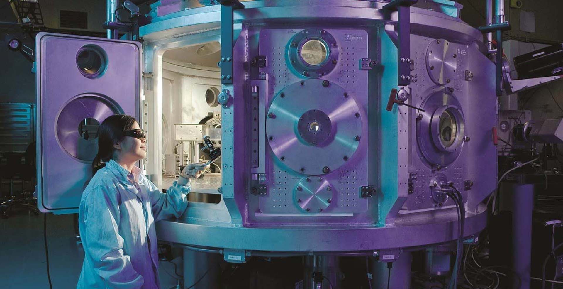 Person sitting by a large machine